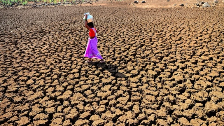 Woman carrying a jug of water and walking on parched ground Racaille1950, Wikimedia Commons