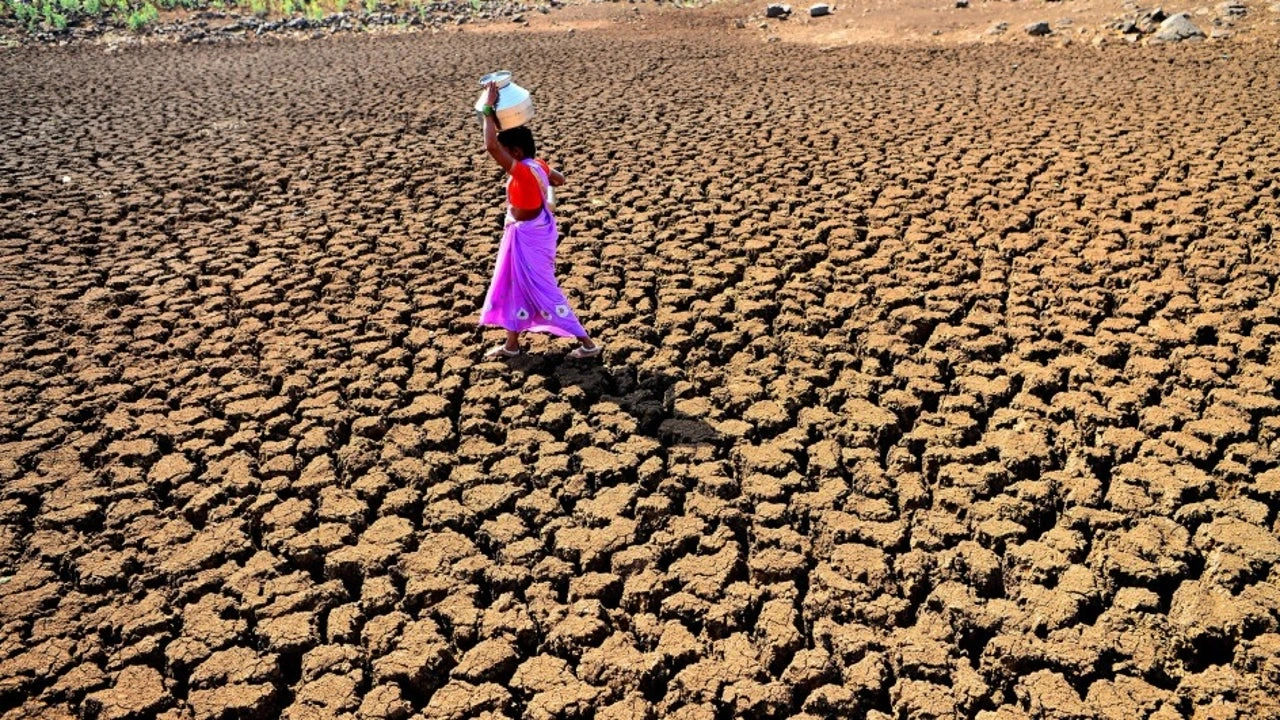 Woman carrying a jug of water and walking on parched ground Racaille1950, Wikimedia Commons