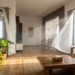 Open windows and an exhaust fan circulate fresh air through a sunlit living room.